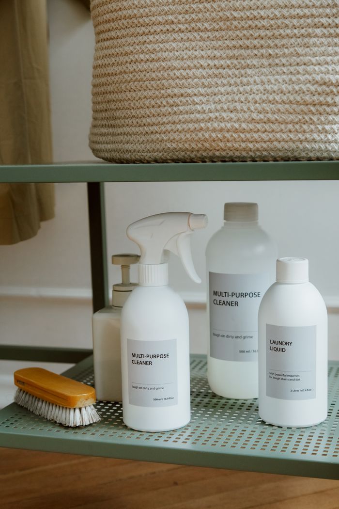 A neatly arranged collection of cleaning supplies on a metal shelf.